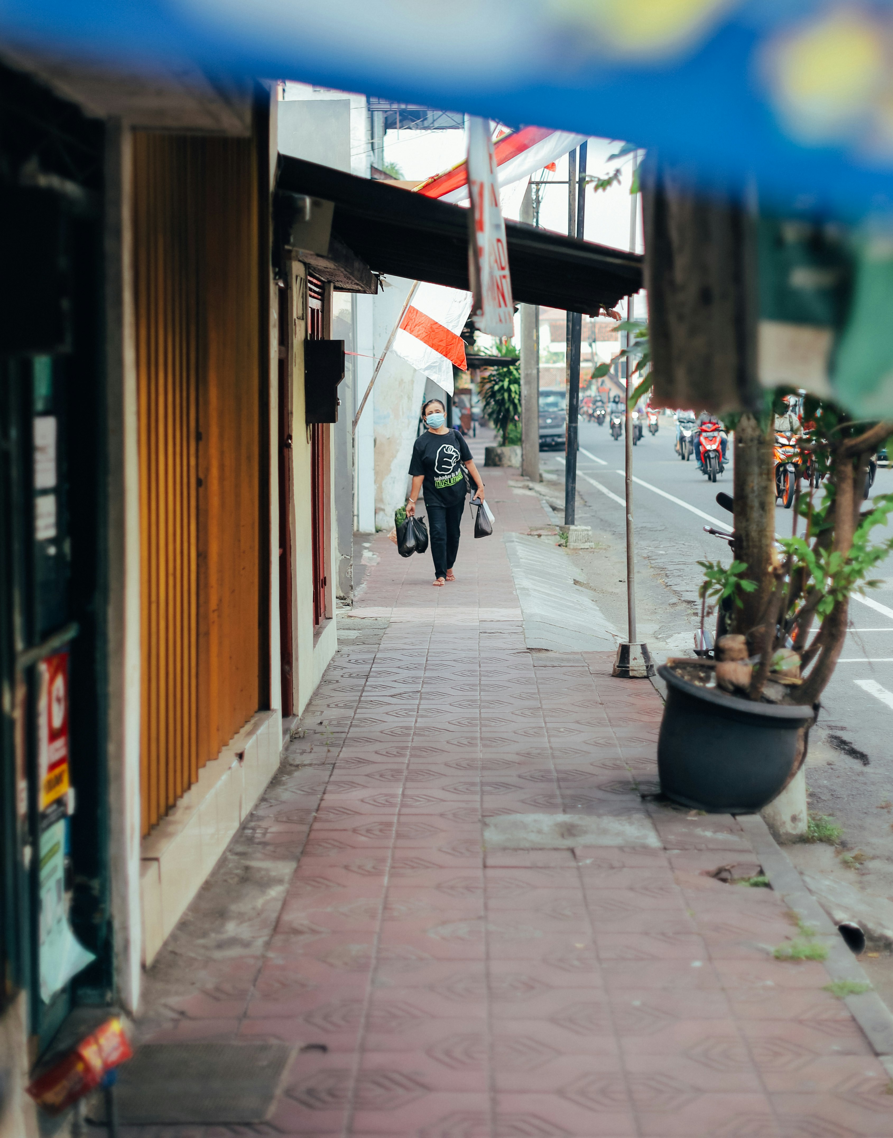 woman in black jacket walking on sidewalk during daytime